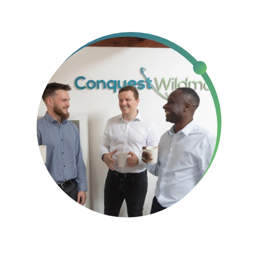 Conquest wildman team standing together talking in the office